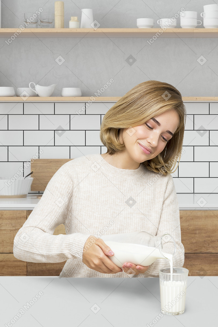 A woman sitting at a table and pouring milk