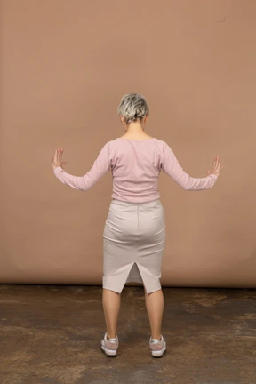 Vista trasera de una mujer en ropa casual que muestra el tamaño de algo