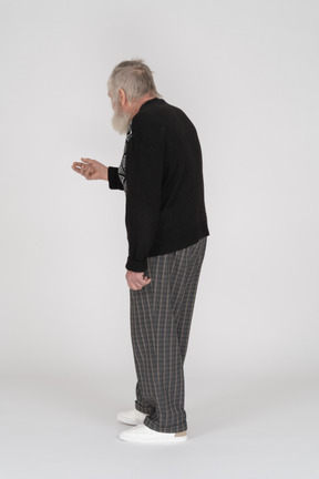Vista posteriore di un uomo anziano che allunga la mano
