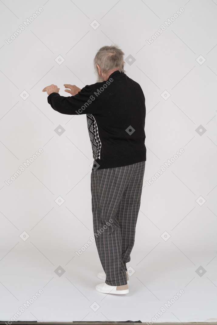 Rear view of old man outstretching hands