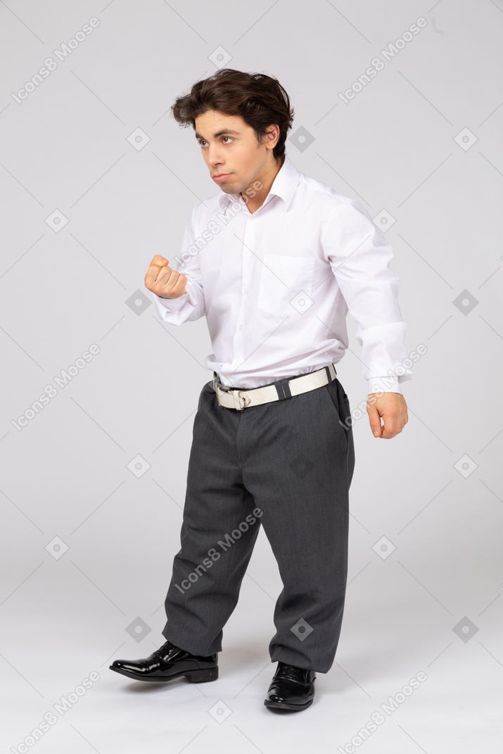 Side view of man with clenched fist threatening