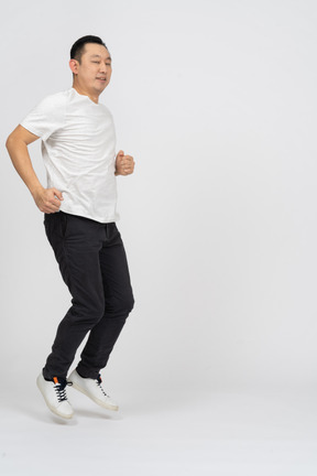 Side view of a jumping man looking at camera