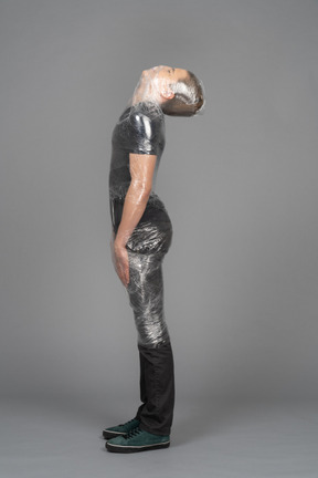 Side view of a young man wrapped in plastic