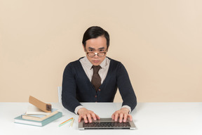 Joven estudiante asiática escribiendo en una computadora portátil