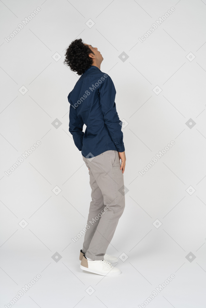 Vista lateral de um homem com roupas casuais olhando para cima