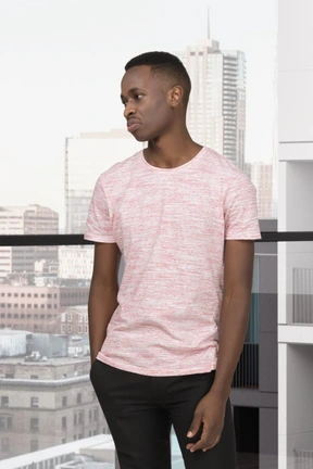 A young man standing in front of a window