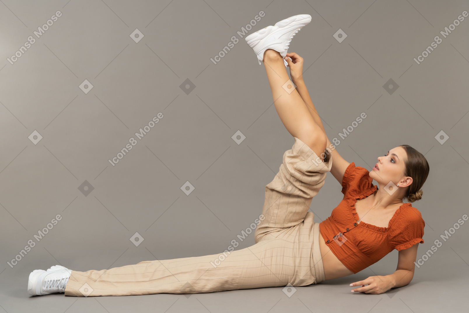 Jeune femme se couche et met sa jambe en l'air