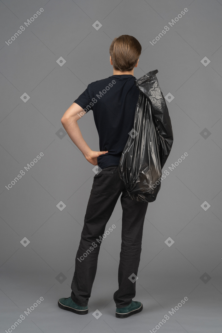 A man holding a trash bag behind his back