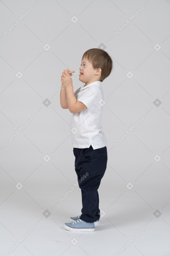 Side view of boy holding his own hand