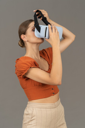 戴上虚拟现实耳机的年轻女性的四分之三视图