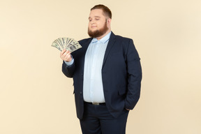 A plus-size man in a black costume with dollar bills in his hands