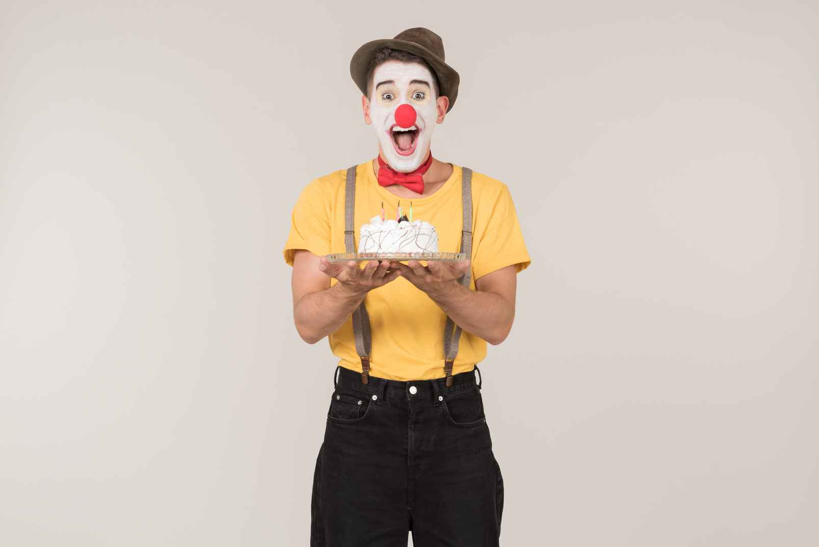 Excited male clown holding a cake