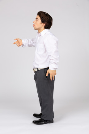 Side view of young man standing and gesturing