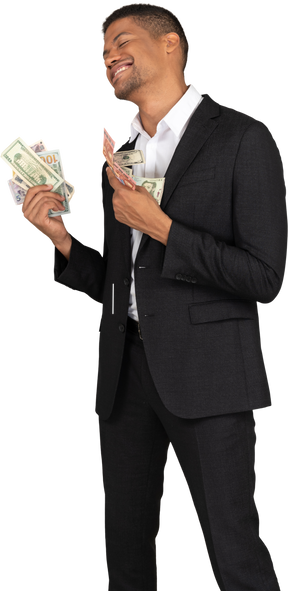 Three-quarter view of a smiling young man in black suit holding banknotes