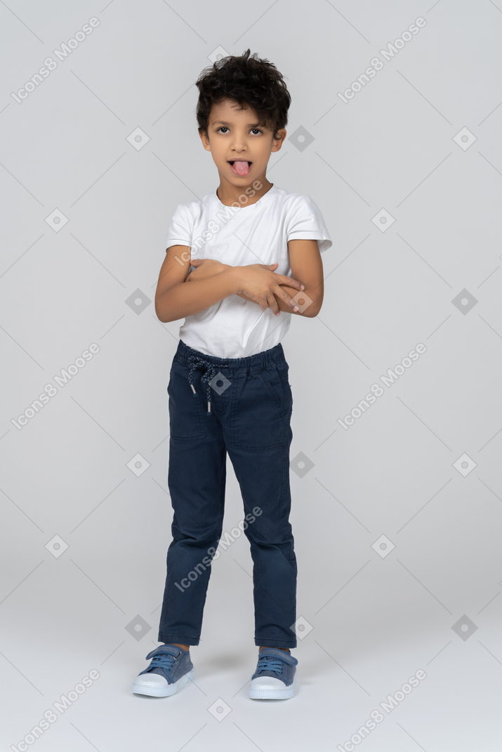 Intrigued boy standing with his arms crossed
