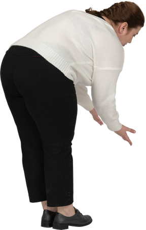 Vista laterale di una donna grassoccia in abiti casual che si piega