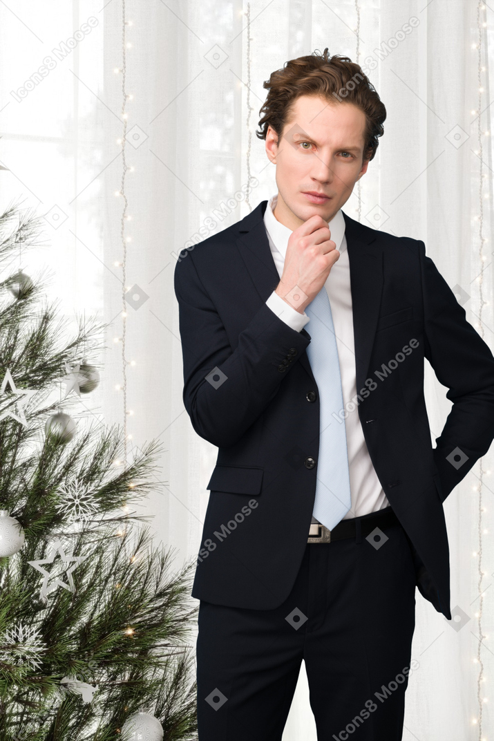 Geschäftsmann, der nahe einem weihnachtsbaum steht