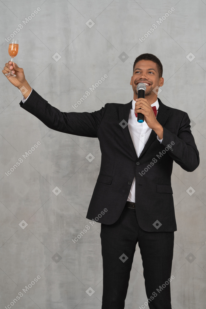 Delighted man with mic raising a champagne glass