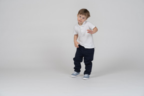 Three-quarter view of a boy standing on one leg