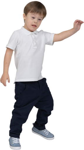 Three-quarter view of a boy walking and raising hand