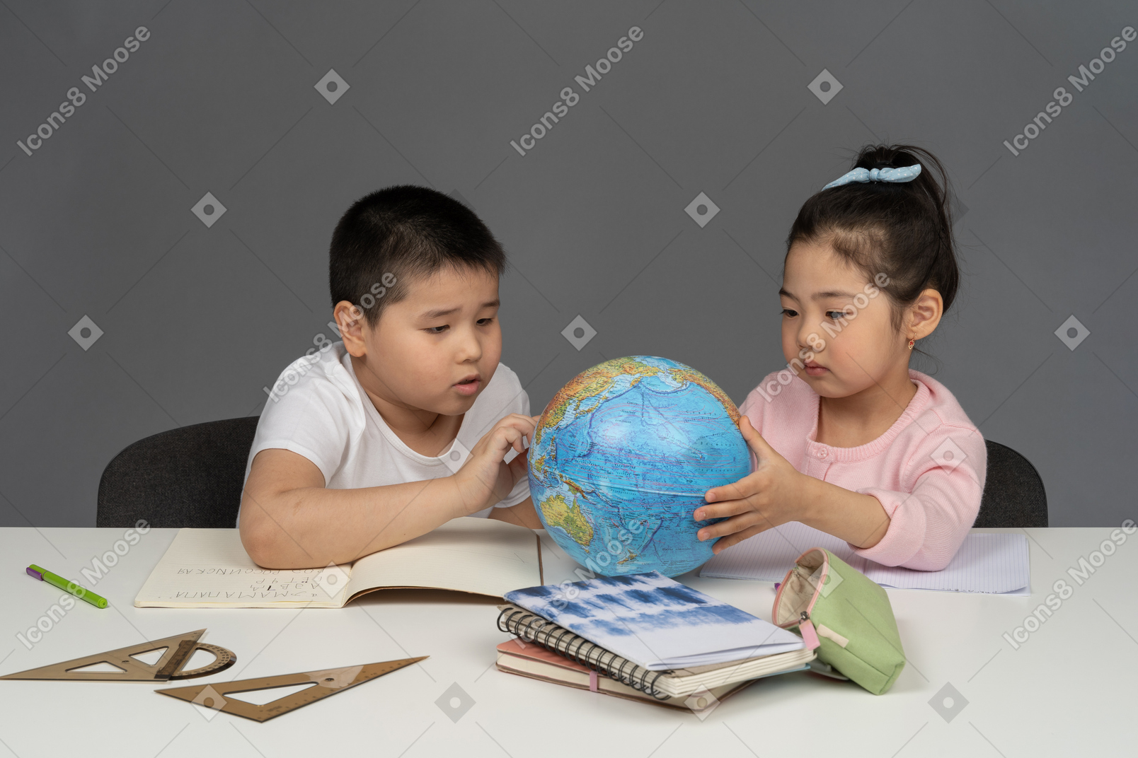 Boy and girl looking at a desk globe