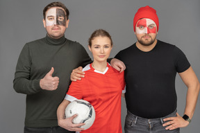 A portrait of two football male fans with female soccer player