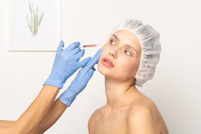 Femme qui a l'air effrayée de se faire injecter du botox