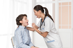 A young boy is being examined by a nurse