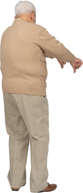 Vista traseira de um velho em roupas casuais, mostrando os polegares para baixo