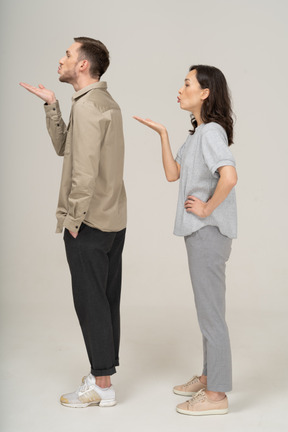 Side view of young couple blowing a kiss