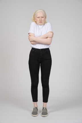 Front view of a young girl standing and feeling cold