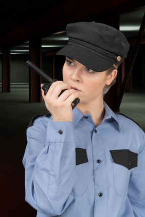 Policewoman talking on walkie talkie at a parking garage