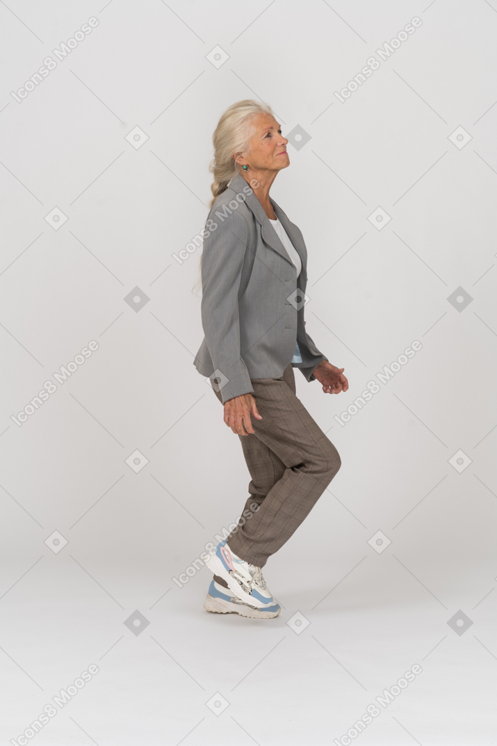 Side view of an old lady in suit walking