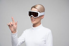 Woman in ski goggles using digital interface