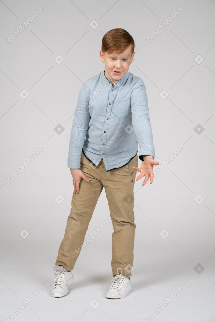 Front view of a cute boy pointing at something