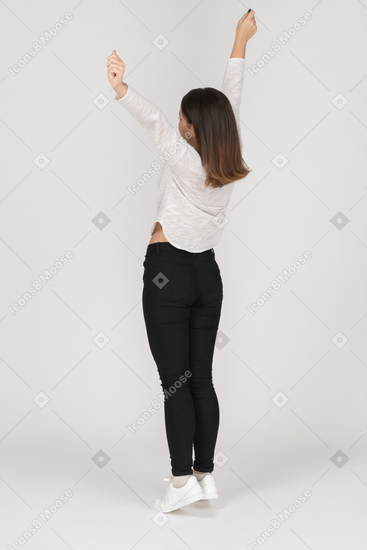 Back view of an awaken young indian female in casual clothes stretching her arms