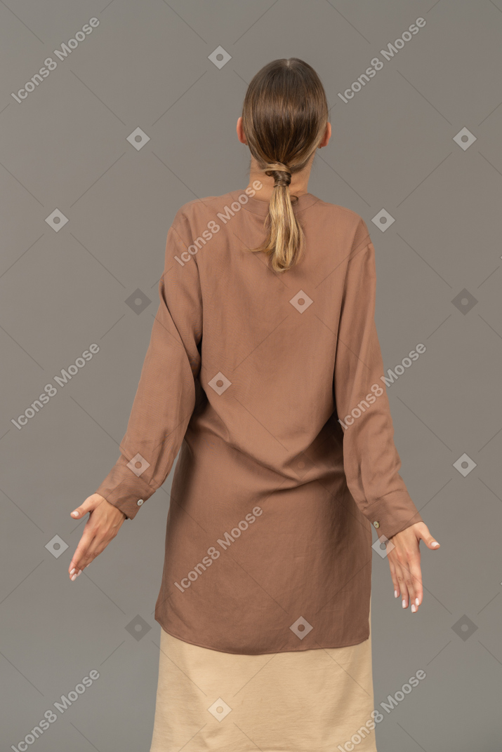 Back view of a young woman with open arms