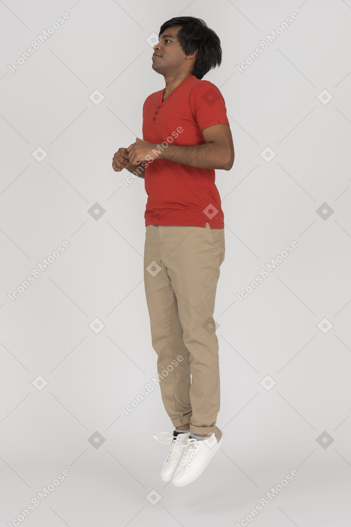 Young man jumping with bent arms