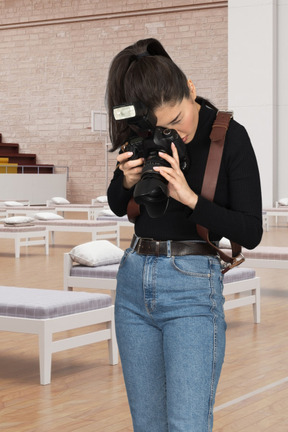 A woman holding a camera in a room