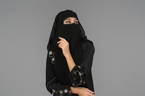 Una mujer musulmana cubierta mirando hacia arriba