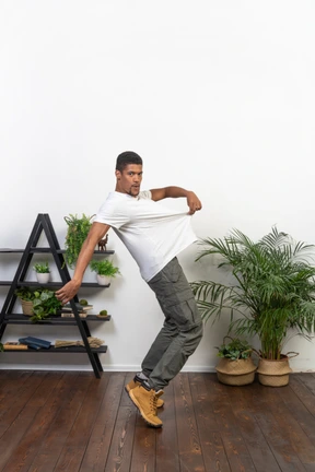 Handsome athletic man posing on the background of the apartment