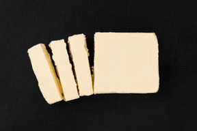 Cut block of butter on black background