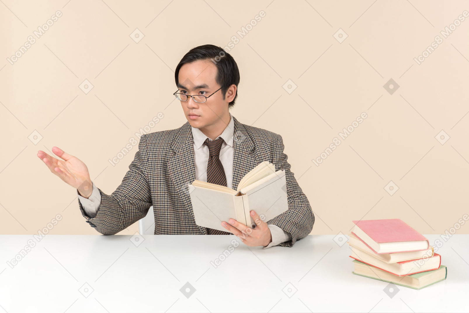 Um professor asiático de terno xadrez, gravata e livro na mão, trabalhando com a turma