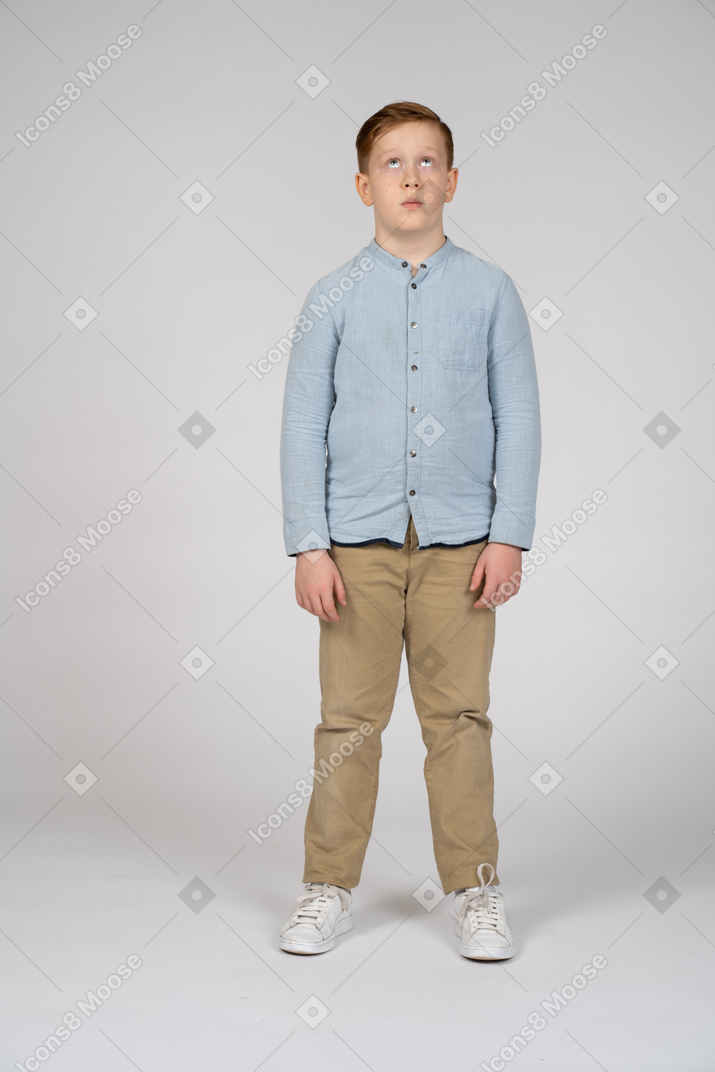 Boy in casual clothes looks up