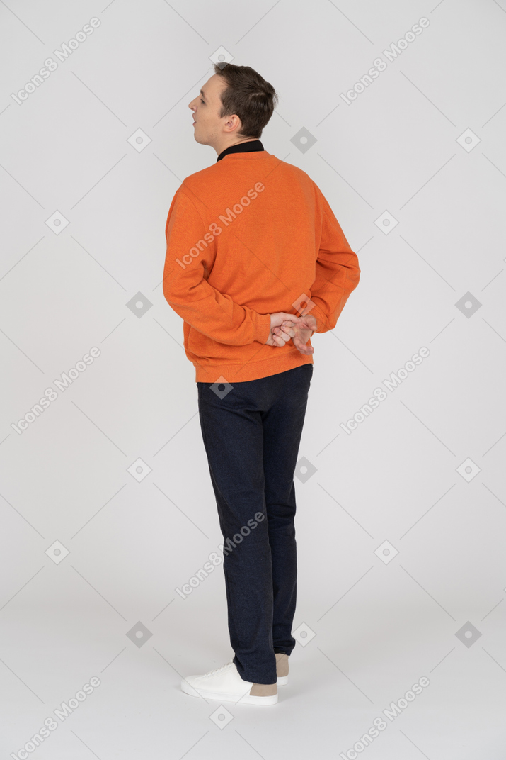 Young man in orange sweatshirt standing