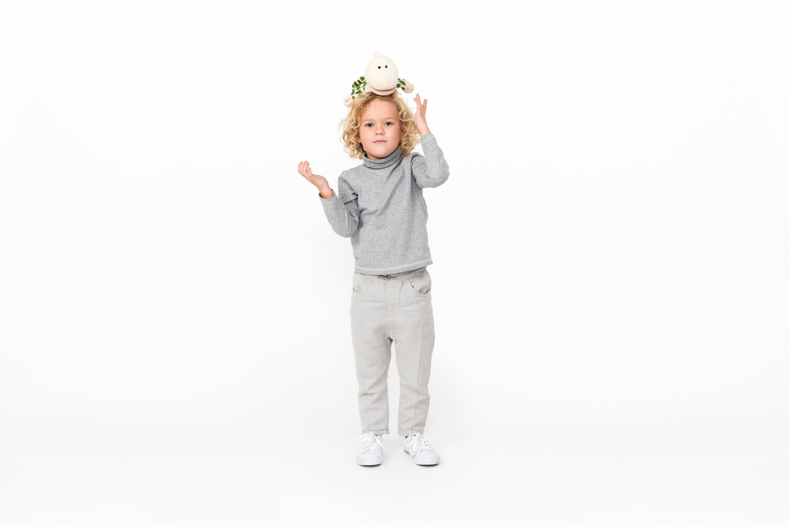 Kid boy standing with toy on his head
