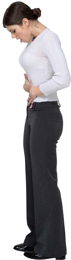 Side view of a young woman in office clothing touching stomach