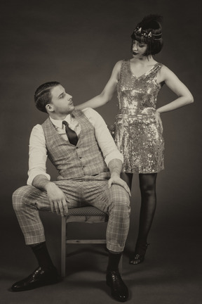 A well-dressed flapper and a gentleman looking at each other