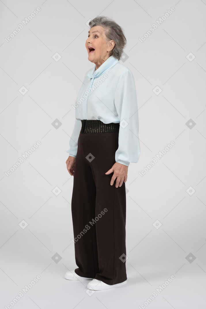 Side view of an old woman with her mouth open widely in shock