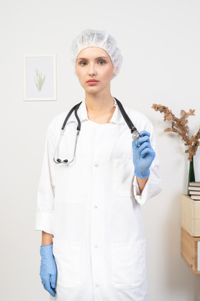 Front view of a young female doctor holding stethoscope